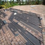 Wind,damaged,house,roof,with,missing,asphalt,shingles,after,hurricane