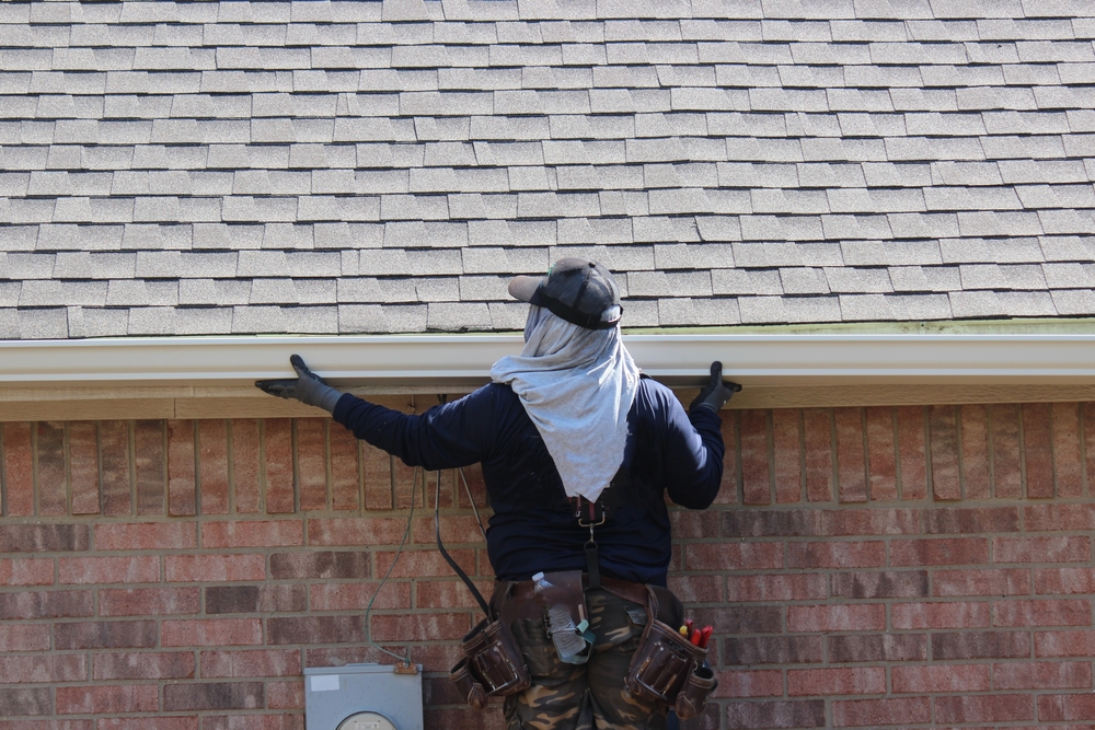 Contractor,installing,new,roof,gutters,in,a,residential,house,in