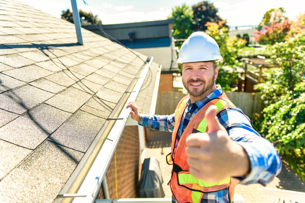 A,man,with,hard,hat,standing,on,steps,inspecting,house