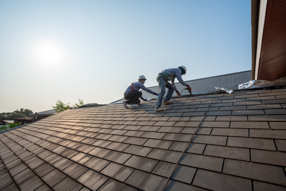 Roofer,worker,in,special,protective,work,wear,and,gloves,using,pneumatic