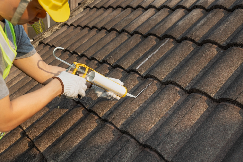 Worker,man,using,silicone,sealant,adhesive,to,fix,crack,of