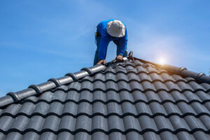Roof,repair,,worker,with,white,gloves,replacing,gray,tiles,or